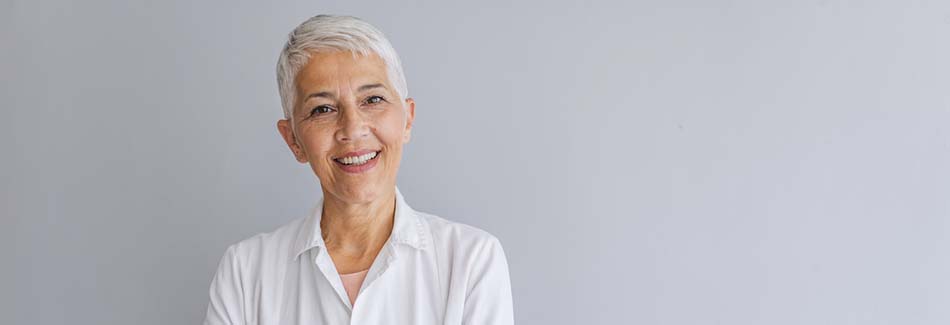 A doctor with short white hair smiles with her arms crossed at Carroll County medical clinic