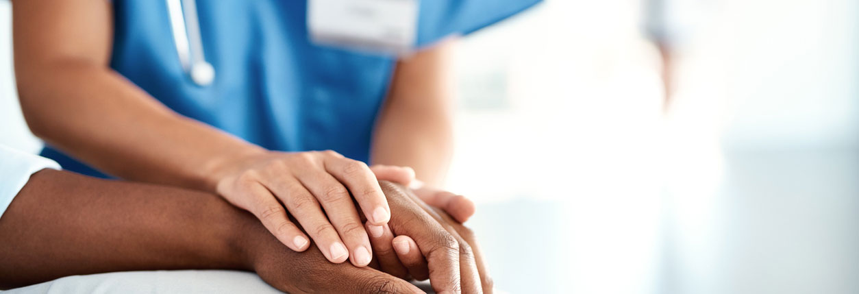 A doctor offers a comforting hand to a hospital patient. 